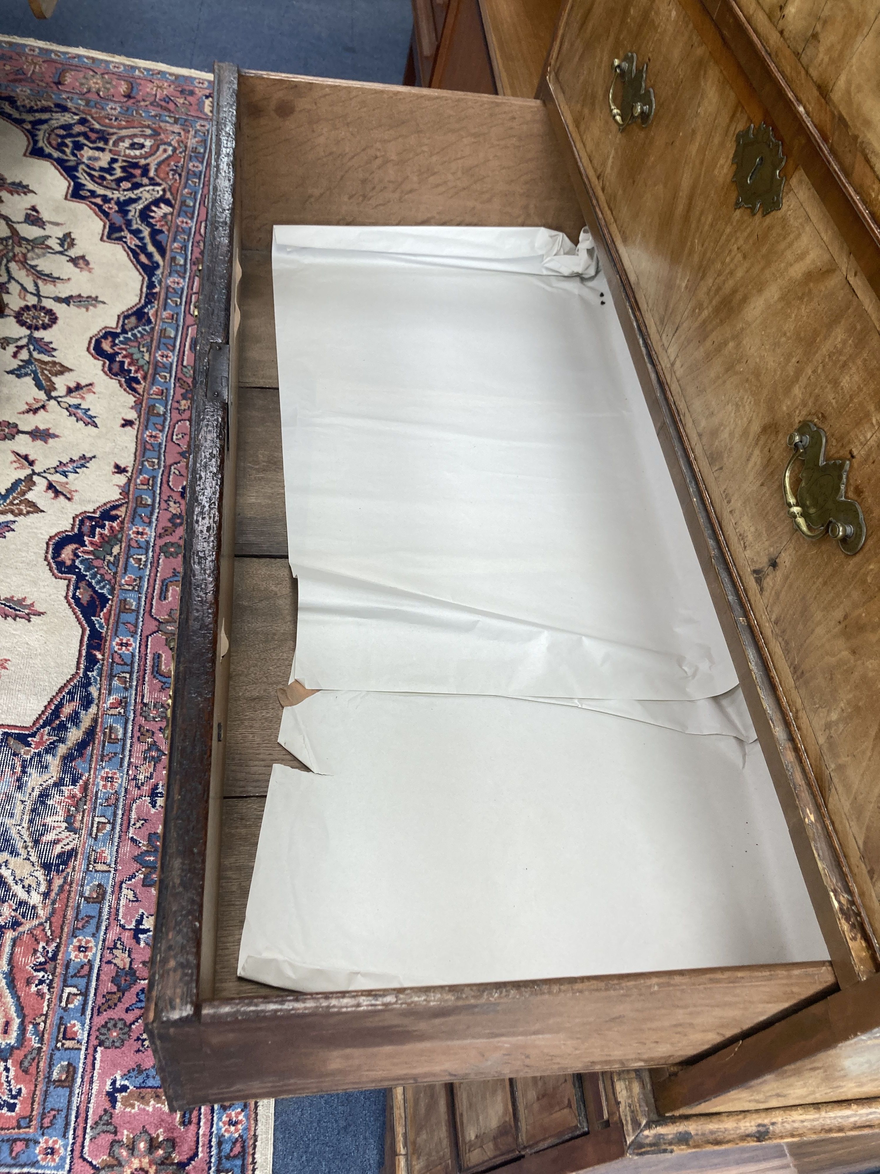 An early 18th century banded walnut tallboy, with oak sides, fitted three small and six long drawers with a brushing slide, width 105cm